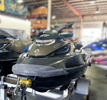 Two jet skis on a stand in a showroom with 'Sea-Doo' branding.