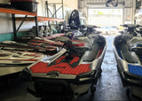 Two jet skis in a showroom with various items in the background
