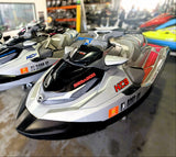 Two jet skis on display in a showroom with 'HCB' branding.