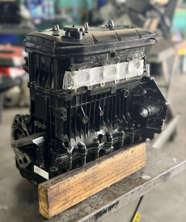 Vintage engine block on a wooden platform with a blurred background
