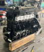 Vintage engine block on a wooden platform with a blurred background