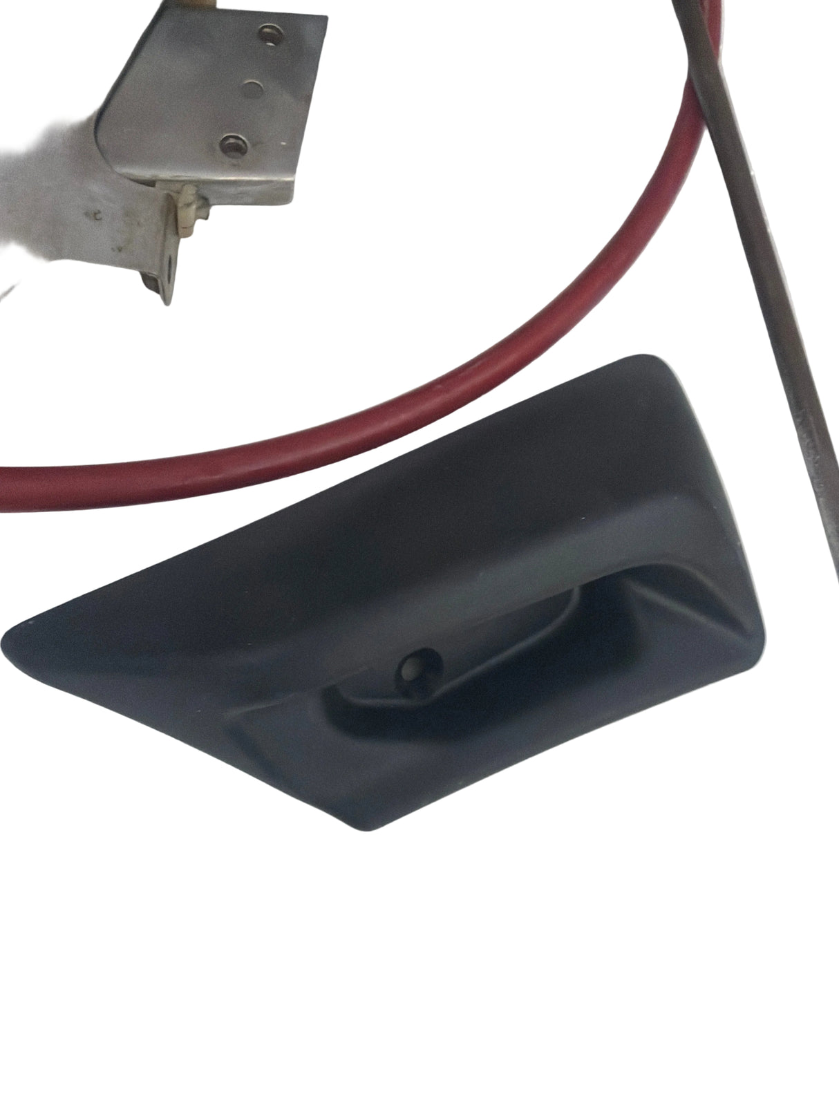 Black plastic component on a white surface with clear plastic sheeting